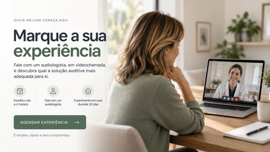 Uma mulher em casa conversa por videochamada com uma audiologista.